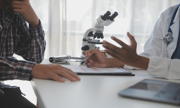 Laboratorio professionale Incredibile operatore medico dai capelli lunghi che indossa l'uniforme mentre utilizza il microscopio durante la ricerca