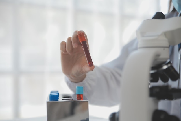 Laboratorio professionale Incredibile operatore medico dai capelli lunghi che indossa l'uniforme mentre utilizza il microscopio durante la ricerca