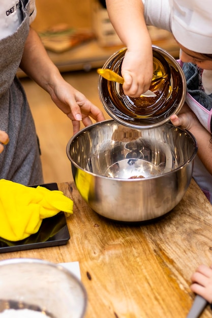 Laboratorio sui biscotti di Natale Il pasticcere aggiunge il miele aiutato da una ragazza