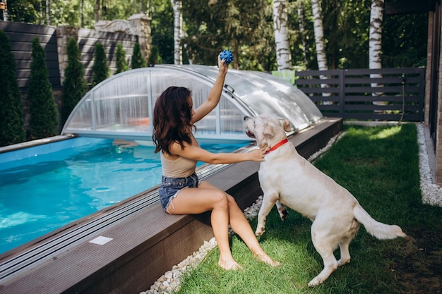 Labrador e la ragazza si godono l'acqua blu di una piscina in estate