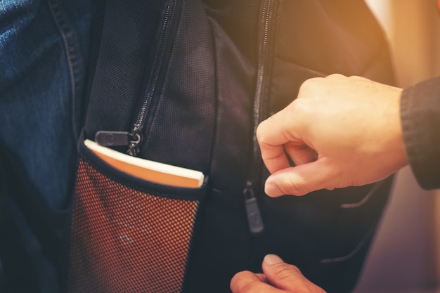 Ladro cerca di rubare il portafoglio nello zaino, rubando borsa da viaggio per strada in grande