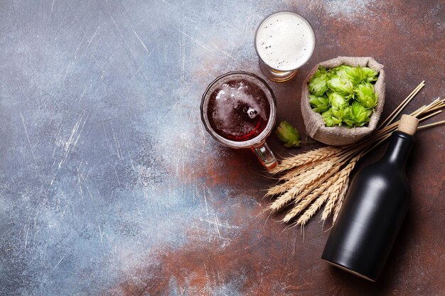 Lager boccale di birra bottiglia luppolo e grano sul vecchio tavolo di pietra