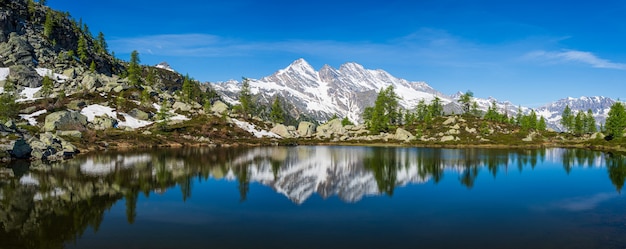 Lago alpino in un ambiente idilliaco con rocce e foreste