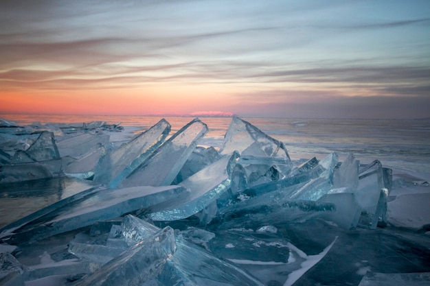 Lago Baikal al tramonto, tutto è coperto di ghiaccio e neve, denso ghiaccio blu chiaro. L