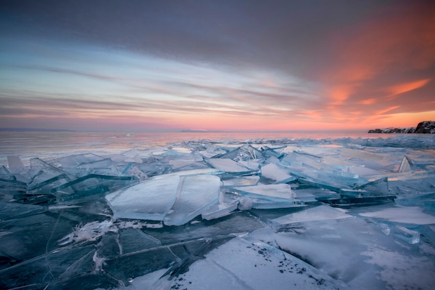 Lago Baikal al tramonto, tutto è coperto di ghiaccio e neve, ghiaccio azzurro e denso. Lago Baikal nei raggi del sole al tramonto. Posto incredibile, patrimonio mondiale dell'UNESCO?