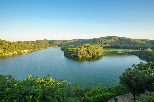 Lago calmo circondato da colline e alberi