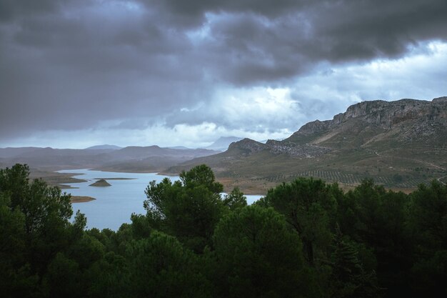 Lago con montagne in tempesta