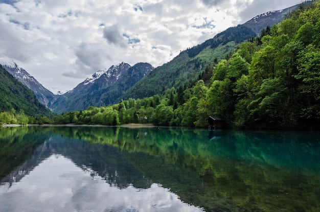 Lago con riflesso con montagne e foreste