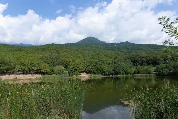 Lago di montagna circondato da montagne di velluto Crimea e cielo azzurro con nuvole Paesaggio di montagna