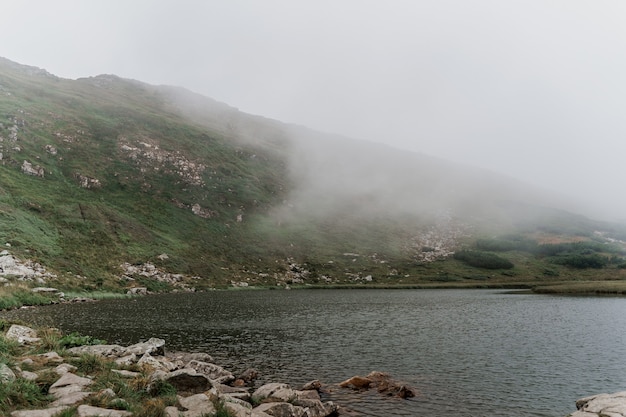 Lago di montagna e in una giornata nebbiosa