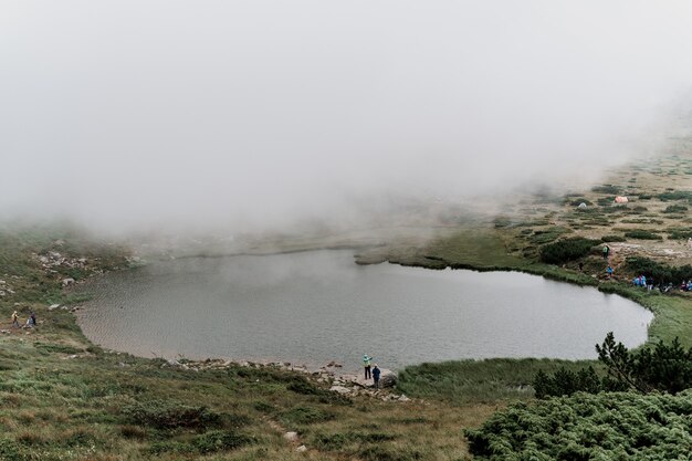 Lago di montagna e in una giornata nebbiosa