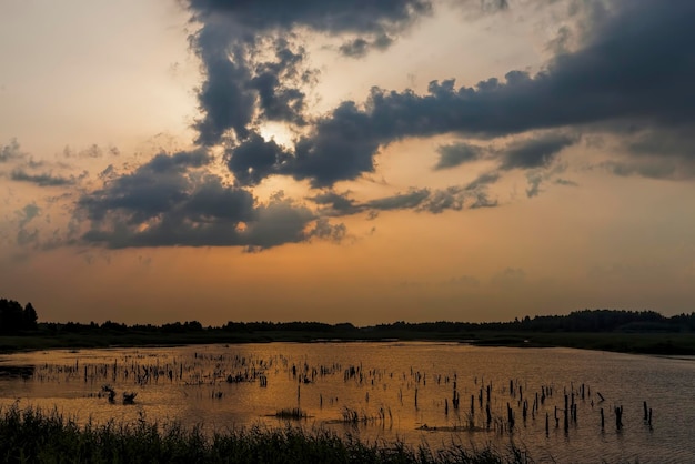 Lago durante il tramonto con cielo giallo-arancio