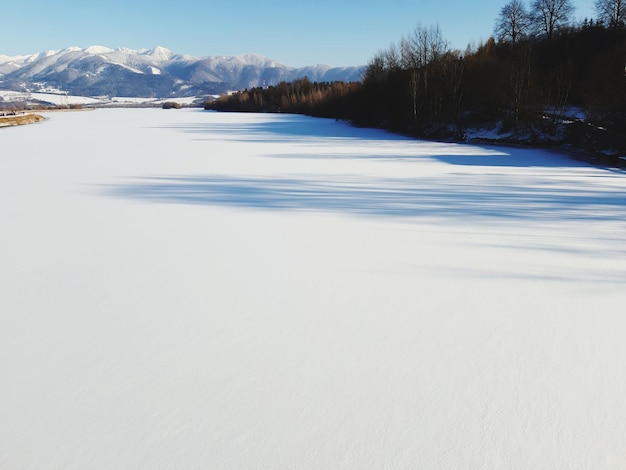 Lago ghiacciato e montagne coperte di neve