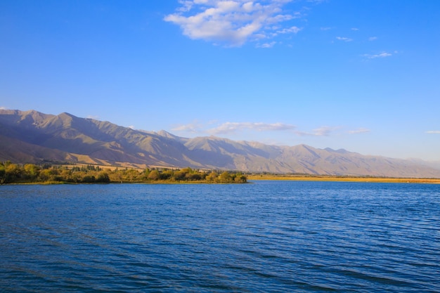 Lago in montagna Bella natura riflesso di nuvole e montagne in acqua blu Kirghizistan Lago IssykKul