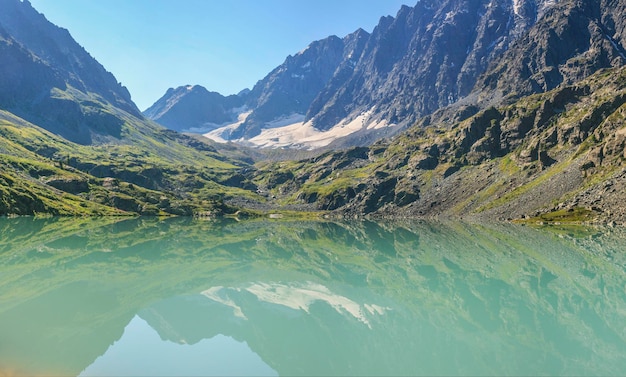 Lago selvaggio nelle montagne dell'Altai Mattina d'estate riflessa nell'acqua