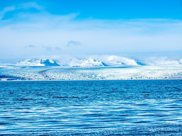 Laguna dell'iceberg di Jokulsarlon nella stagione invernale con ghiacciaio e iceberg sotto il cielo nuvoloso in Islanda