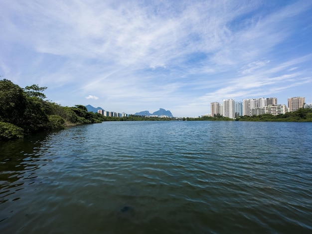 Laguna Marapendi con vegetazione di edifici e alberi intorno alle colline e ponte Barra da Tijuca sullo sfondo Situato vicino a Praia da Reserva a Rio de Janeiro