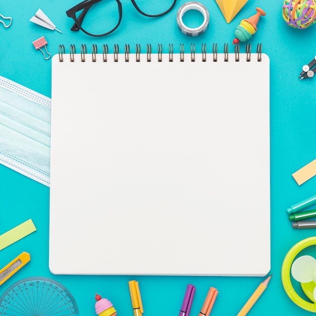 Laici piatta di ritorno a materiale scolastico con matite e quaderno