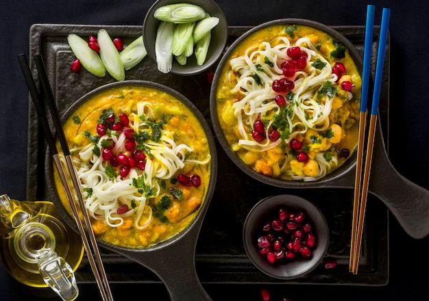 Laksa con zucca e latte di cocco, spaghetti di riso, broccoli e semi di melograno