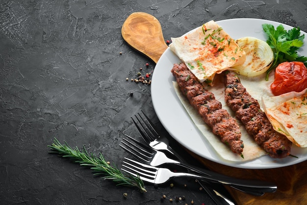 Lamb Kebab Pita pane e spezie su sfondo nero Vista dall'alto