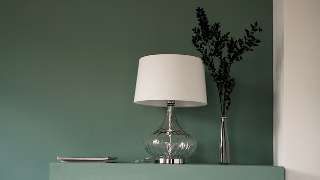 Lampada da terra bianca e vaso su sfondo verde moderno interno minimalista. Colore menta pallido. Design d'interni moderno