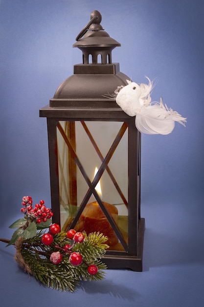 Lampada vintage con candele, ramo di Natale con ornamenti, uccello bianco sulla lampada.