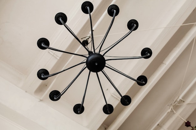 Lampadario retrò in metallo nero sul soffitto all'interno del sottotetto. arredamento vintage