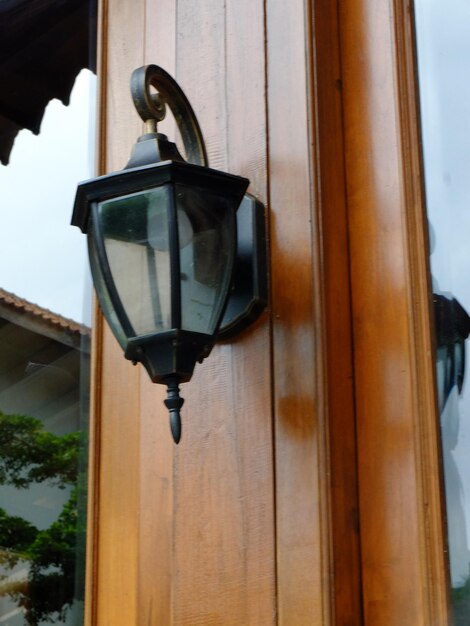 Lampadario vintage in metallo nero. Appesa alla porta in legno di teak di una casa giavanese. Lampugantung.