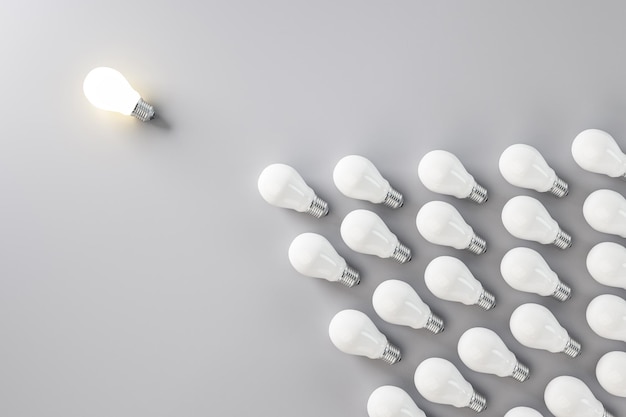 Lampadina incandescente e molte lampadine a forma di freccia su sfondo grigio Idea e concetto di leadership Rendering 3D