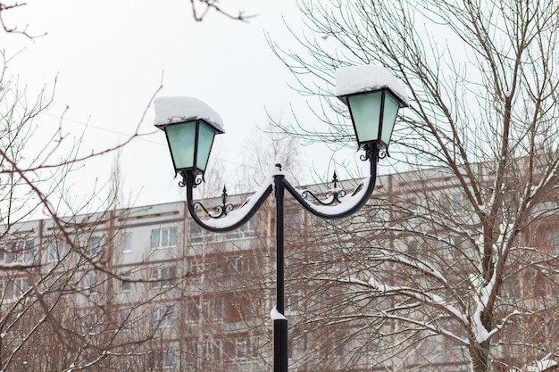 Lampione nel parco invernale. Casa popolare sullo sfondo