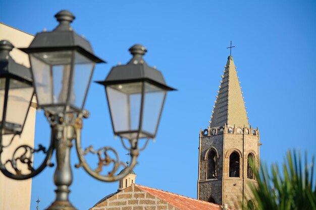 Lampione sfocato con il campanile di Alghero sullo sfondo