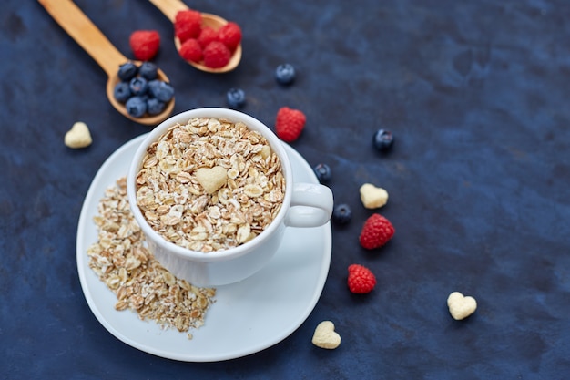 Lamponi e mirtilli su sfondo blu. Cereali.