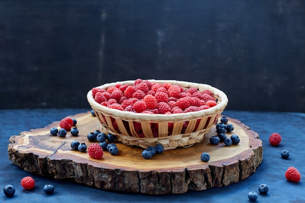 Lamponi e mirtilli sull'azzurro. Cereali.