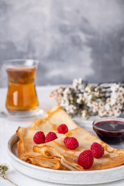 Lamponi freschi dei pancake su una zolla.