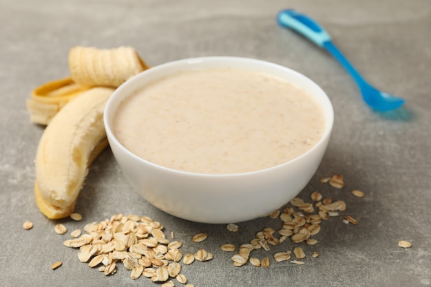 Lanci con porridge su fondo grigio, fine su. Cibo per bambini