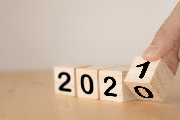 Lanciando a mano blocchi di legno per cambiare gli anni dal 2020 al 2021. Anno nuovo e concetto di vacanza.