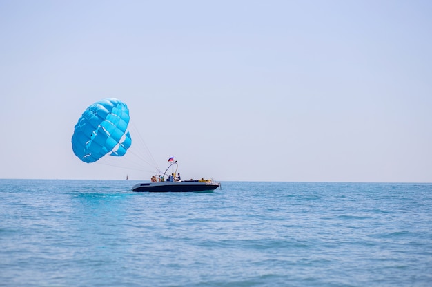 Lancio di un paracadute con i turisti da una barca in mezzo al mare. Attività da spiaggia nel tempo libero