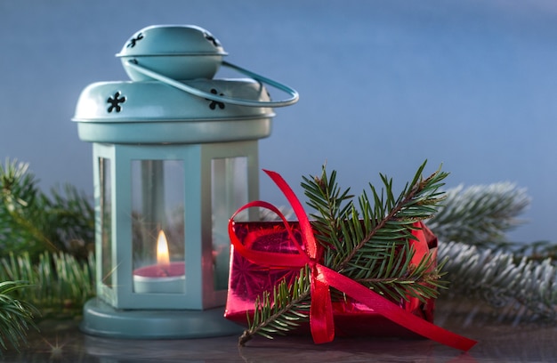 Lanterna di Natale sulla neve con abete e regali. Anno nuovo, buone feste