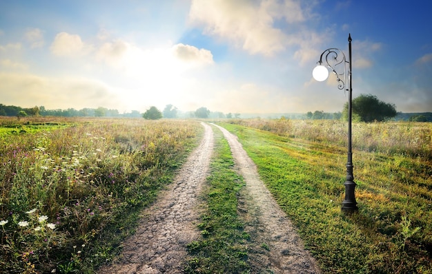 Lanterna vicino alla strada di campagna al mattino di primavera