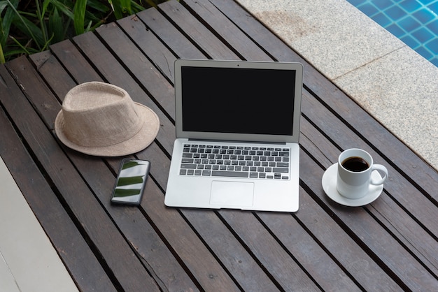 Laptop e cappello in piscina.