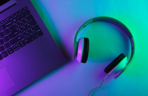 Laptop e cuffie con luce al neon verde e viola