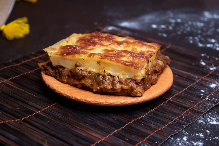 Foto lasagna di manzo servita in piatto isolato su uno sfondo scuro vista laterale del fast food bangladeshi