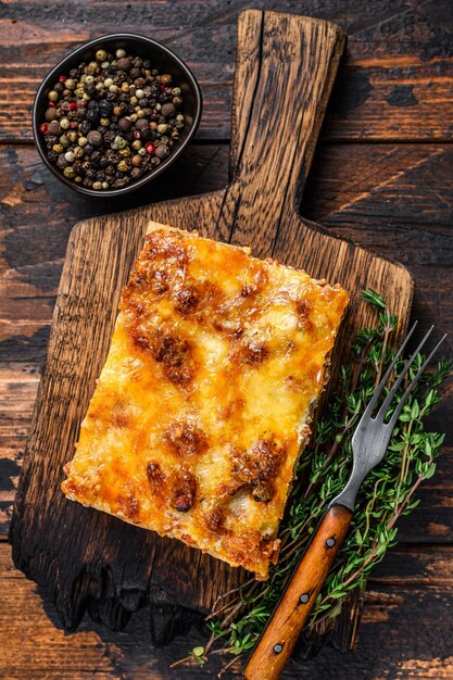 Lasagne all'italiana con ragù alla bolognese e carne di manzo tritata. Fondo di legno scuro. Vista dall'alto.