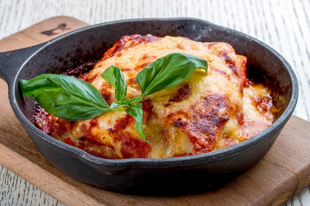 Lasagne in padella di ghisa su tavola di legno Piatto tradizionale italiano