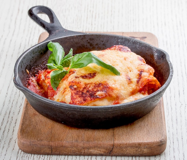 Lasagne in padella di ghisa su tavola di legno Piatto tradizionale italiano