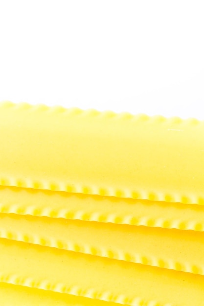 Lasagne organiche gialle su sfondo bianco.