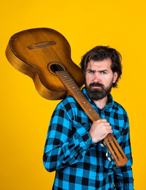 Lascia che la musica parli. chitarrista maschio con chitarra acustica. concetto di musica. uomo barbuto in camicia a scacchi che suona la chitarra. ragazzo cantante di musica country. hipster con i capelli lunghi e i baffi canta una canzone.