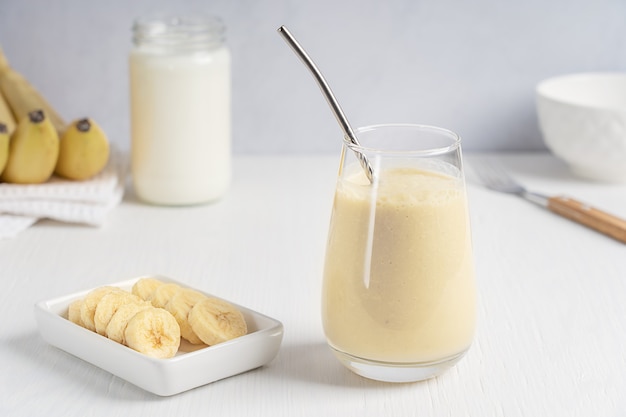 lassi bevanda tradizionale indiana a base di yogurt frullato con banana servita in bicchiere con fettine di frutta