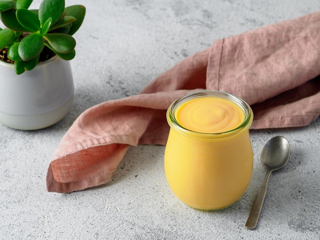 Lassi di mango giallo su sfondo grigio. Bevanda indiana di yogurt al mango con copia spazio a sinistra.