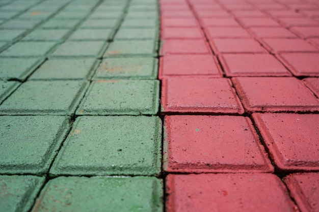 lastre di blocchi di pavimentazione di colore rosso verde in città, strada pedonale, struttura della pavimentazione, percorso piastrellato,